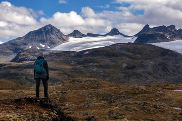 Obraz premium Hiker/Woman looking at smørstabbreen glacier in Jotunheimen NP in Norway