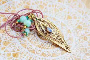 brass pendant with mineral moon stone in shape of joni on decorative background