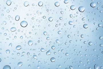 Blue Drops water drops on glass surface as background.