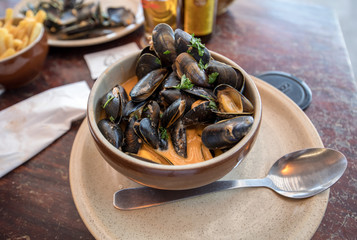 Closeup of traditional dish of French cuisine, appetizing seafood soup with  mussels served in ceramic plate
