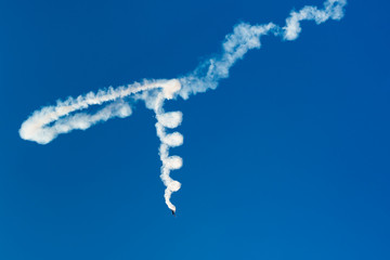 Naklejka premium An Airplane Leaving a Beautiful Spiral-Like Trail of Smoke in the Sky