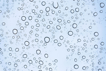 Fototapeta na wymiar Blue Drops water drops on glass surface as background.