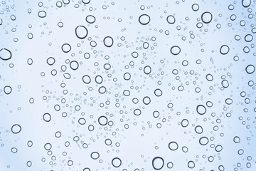 Blue Drops water drops on glass surface as background.