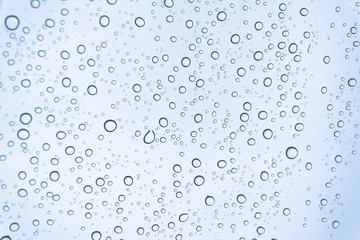 Blue Drops water drops on glass surface as background.