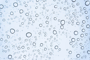 Blue Drops water drops on glass surface as background.