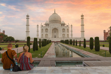 Taj Mahal at dawn with tourist couple enjoying a romantic moment at Agra India