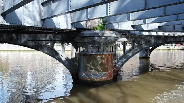 Static shot of water ripples and reflections under queens bridge in Melbourne, Australia