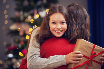 Daughter and father with present over Christmas tree