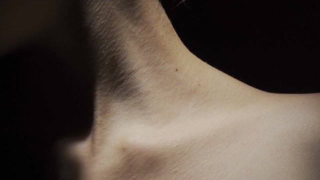 Video of female neck in shadow