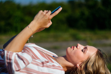 Young woman with cell phone relaxing in the park