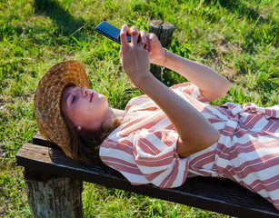 Young woman relaxing on the bench in the park