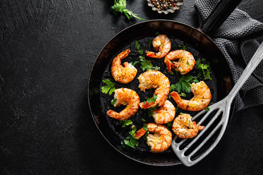 Grilled shrimps on pan on dark background