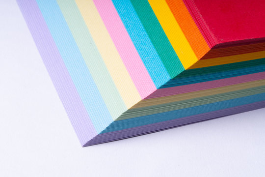 Colored paper stack on white background, close up, high resolution