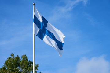 Flag of Finland outdoors against a blue sky.