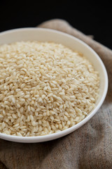 Organic Arborio rice in a white bowl, side view. Close-up.