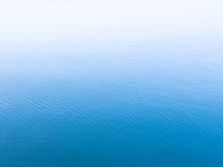 Unique blue background. Blue sea water surface texture background with white copy space on top.