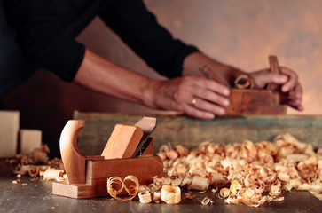 Old wooden jointer and shaving on wooden table.