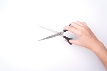 Fashion woman's hand with a gentle manicure holds a tool. Safe work, place for an inscription. View from above. White background, contrasting shadow.