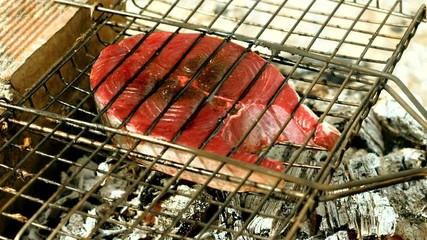 Close-up shot of delicious grilled tuna fish on barbecue grill. 4K