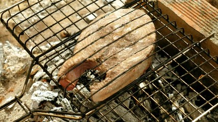 Close-up shot of delicious grilled tuna fish on barbecue grill. 4K
