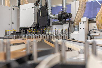 a close-up of a machine transporting plastic edges of different colours in one guide