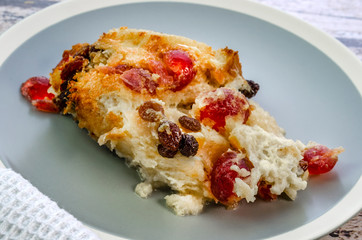 A close up of a portion of freshly baked bread and butter pudding served on a plate.