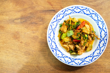 Stir-fried spicy red curry chili with pork in vintage dish in top view with copy space. Thai local food delicious recipe.