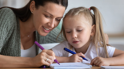 Painstaking daughter and mother draw together with felt-tip pens