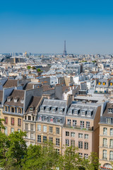 Fototapeta na wymiar Paris, typical buildings and roofs in the Marais, aerial view from the Pompidou Center, with the Eiffel Tower in background 