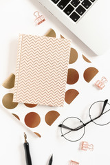Composition with laptop, golden notepads, glasses and stationery