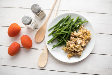 Turkey Stroganoff on white wood table with green beans and seasonings