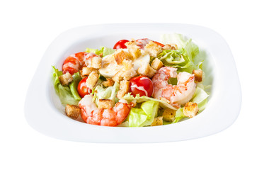 Caesar salad with prawns on white plate isolated