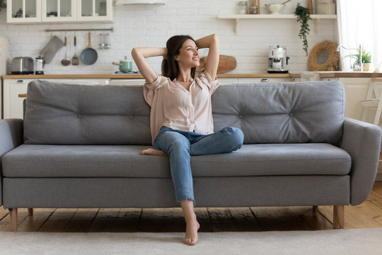 In Cozy Living Room Happy Woman Sitting On Couch Alone