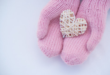Female hands in mittens with heart, close-up
