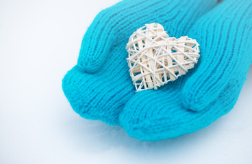 Female hands in mittens with heart, close-up