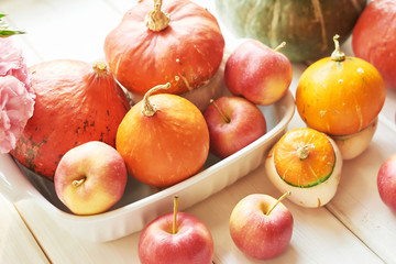 Thanksgiving Day table. Happy Halloween. Pumpkins, apples and flowers. Bright autumn background. Colorful autumn card. Autumn flower arrangement. Autumn bouquet.
