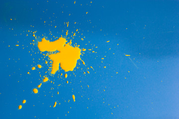 A BLOB of yellow paint on a blue background