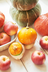 Thanksgiving Day table. Happy Halloween. Pumpkins, apples and flowers. Bright autumn background. Colorful autumn card. Autumn flower arrangement. Autumn bouquet.