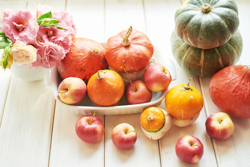Thanksgiving Day table. Happy Halloween. Pumpkins, apples and flowers. Bright autumn background. Colorful autumn card. Autumn flower arrangement. Autumn bouquet.