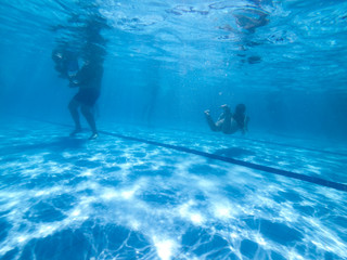 Underwater view from people in a pool in a summer day