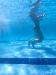 Underwater view from people in a pool in a summer day