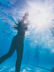 Underwater view from a girl with a red bikini in a pool