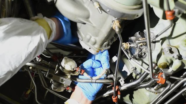 Aircraft Technician using a ratchet on a commercial engine part.
