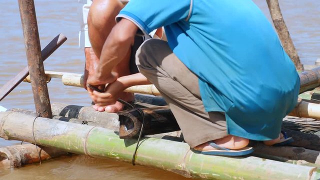 close up of wires twisted like cable ties to secure the bamboo poles together. Bamboo bridge during his construction	