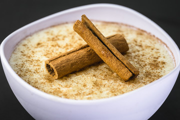 Creamy rice pudding sprinkled with cinnamon, typical Brazilian dessert.