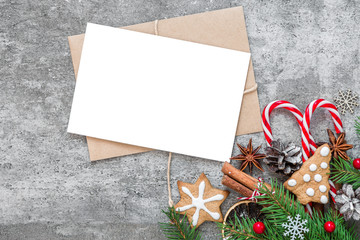 Christmas greeting card with fir branches, decorations, berries, candy and pine cones mock up on concrete background