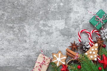 Christmas or New Year background made of fir branches, decorations, berries, candy, gift boxes and pine cones