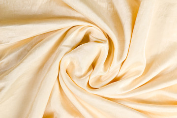 Soft smooth beige silk fabric background. Fabric texture.