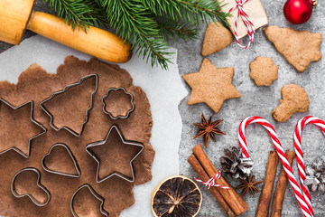 Cooking Christmas gingerbread cookies with fir tree branches and decorations on gray concrete background. top view