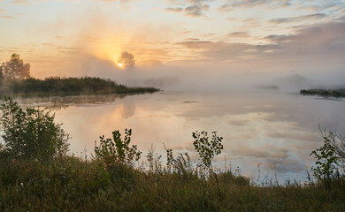 Obraz na płótnie Canvas A quiet dawn over the lake in a Sunny hazy light. Autumn time.